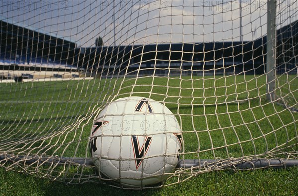 20085445 SPORT Ball Games Football Close shot of football in back of net of goal on soccer pitch.