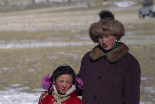 MONGOLIA, Bayan Olgii Province, Kazakh, Portrait of Kazakh woman and her daughter watching the horse races.