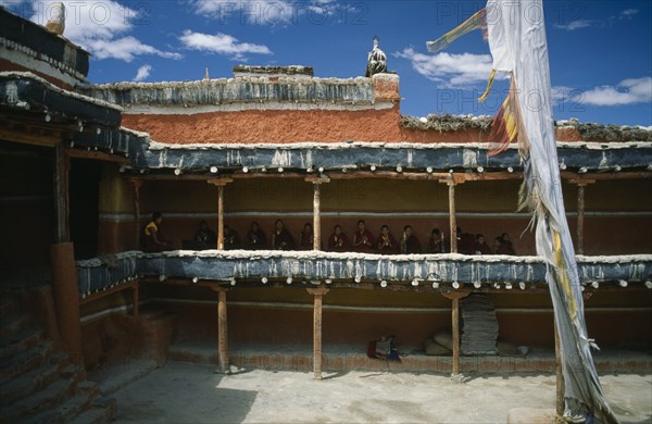 NEPAL, Mustang, Namgyal, Tibetan Buddhist monks awaiting the arrival of the King from upper balcony of temple courtyard.