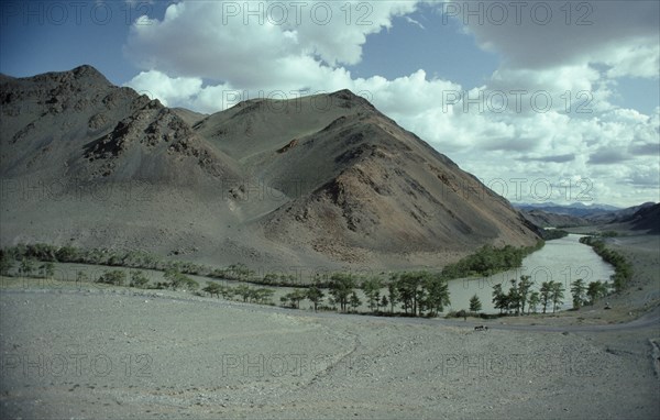MONGOLIA, Hovd River, Bend in river through barren landscape with trees along the river the only vegetation.