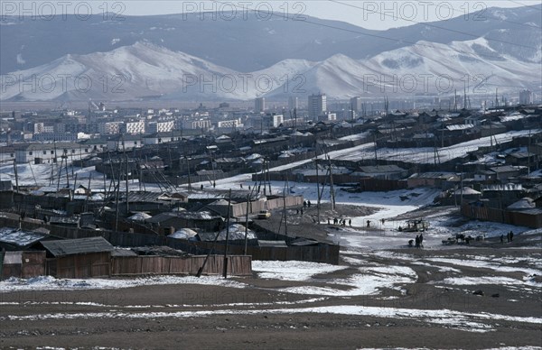 MONGOLIA, Ulan Bator, Traditional housing surrounding Soviet built city centre in winter snow with mountain backdrop.