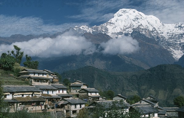 NEPAL, Gandruk, "Gurung village on steep, terraced slope with Annapurna South in the background.  The Gurung are indigenous peoples and devout Buddhists."