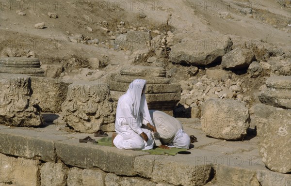 JORDAN, Jerash, Two muslim men pray towrds Mecca.