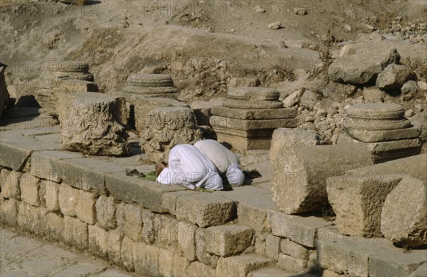 JORDAN, Jerash, Two muslim men pray towrds Mecca.