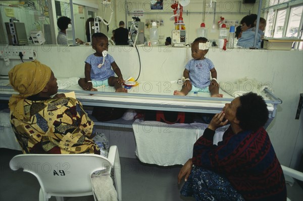 SOUTH AFRICA, Western Cape, Cape Town, Rondebosch neighbourhood.  Rehydration ward in Red Cross children’s hospital.  Child patients receiving treatment with their mothers sitting beside the bed.