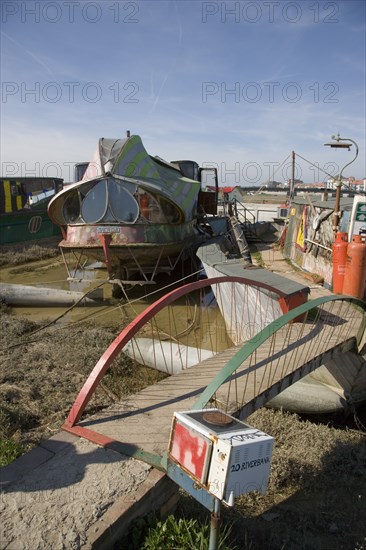 ENGLAND, West Sussex, Shoreham-by-Sea, "Houseboat moored along the banks of the river adur.  Former barges converted into homes with the use of various bits of junk, including cars, buses and washing machines."