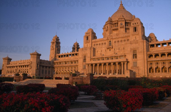 INDIA, Rajasthan, Jodhpur, Umaid Bhawan Palace exterior seen at sunset from gardens