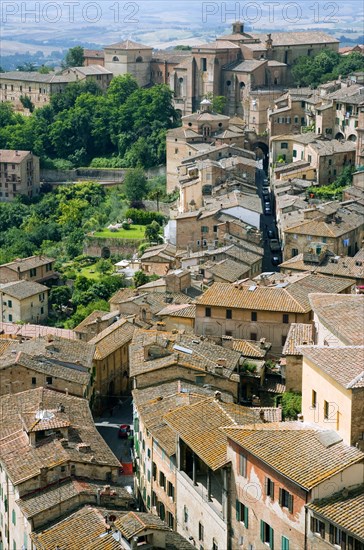 ITALY, Tuscany, Siena, View over rooftops and gardens with a narrow winding medieval street towards the countryside to the west of the city