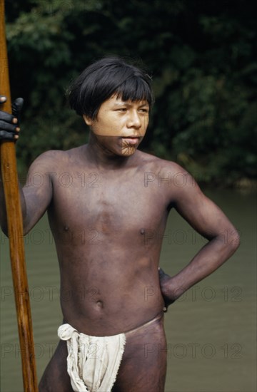 COLOMBIA, Choco, Embera Indigenous People, "Rio Verde, a young Embera  with lower face and body painted with black dye extracted from the inedible Jagua fruit holding a palanca/pole - used for guiding canoe through rapids on rio Condoto. Pacific coastal region tribe body decoration American Colombian Colombia Hispanic Indegent Latin America Latino Male Men Guy South America  Pacific coastal region tribe body decoration American Colombian Columbia Hispanic Indegent Latin America Latino Male Men Guy South America Immature Male Man Guy One individual Solo Lone Solitary 1 Single unitary Young Unripe Unripened Green "