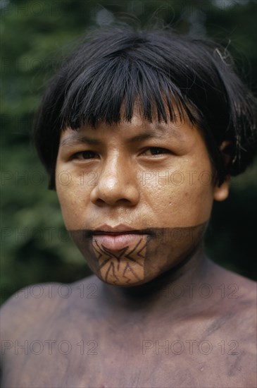 COLOMBIA, Choco, Embera Indigenous People, Portrait of young Embera man named Rio Verde on rio Condoto  with lower face and body painted with black dye extracted from the inedible Jagua fruit  used as decoration for tribal rituals and festivals. Pacific coastal region tribe body decoration American Colombian Colombia Hispanic Indegent Latin America Latino Male Men Guy South America  Pacific coastal region tribe body decoration American Colombian Columbia Hispanic Indegent Latin America Latino Male Men Guy South America Immature Male Man Guy One individual Solo Lone Solitary 1 Indigenous Single unitary Young Unripe Unripened Green
