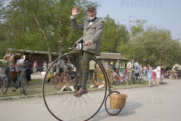 ENGLAND, West Sussex, Amberley, Amberley Working Museum. Veteran Cycle Day Grand Parade. Man wearing period custom riding a Penny Farthing bicycle