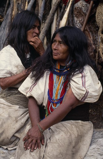 COLOMBIA, Sierra Nevada de Santa Marta, Ika, Portrait of Ika mother and daughter in traditional woven wool&cotton mantas cloaks sitting outside their home  daughter de-lousing her mother's hair. Mother wears necklace of red and blue glass beads  a sign of wealth. Arhuaco Aruaco indigenous tribe American Colombian Colorful Colombia Female Woman Girl Lady Hispanic Indegent Latin America Latino South America  Arhuaco Aruaco indigenous tribe American Colombian Colorful Columbia Female Woman Girl Lady Hispanic Indegent Latin America Latino South America 1 2 Female Women Girl Lady Single unitary Classic Classical Historical Mum Older One One individual Solo Lone Solitary Two