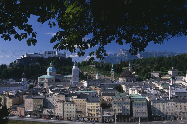 AUSTRIA, Salzburg, "City view from Hettwerr Bastion, part of the old city walls on Kapuzinerberg Hill.  Part framed by tree branches."