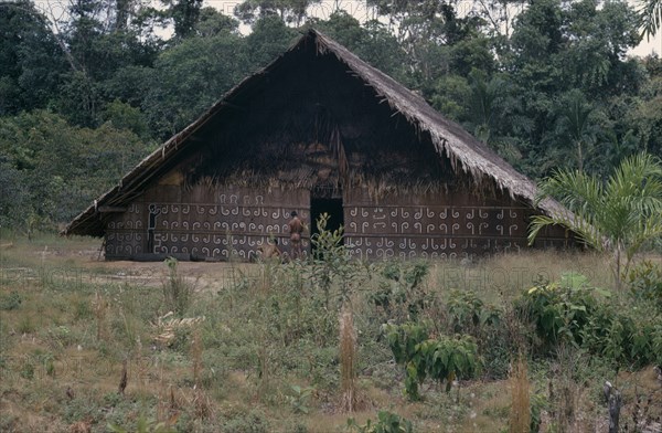 COLOMBIA, North West Amazon, Tukano Indigenous People, "Barasana men painting design, using white and yellow clay and black charcoal, on front of maloca  the communal family home.   Tukano sedentary tribe Indian North Western Amazonia maloca American Colombian Columbia Hispanic Indegent Latin America Latino Male Man Guy South America Tukano "