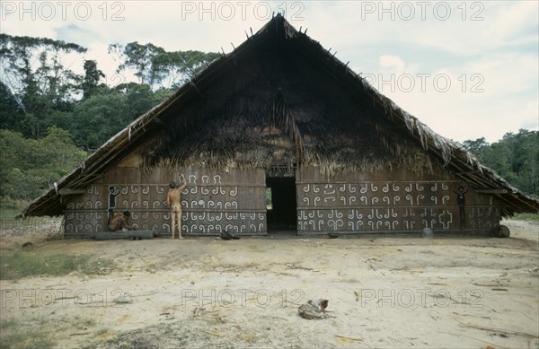COLOMBIA, North West Amazon, Tukano Indigenous People, Barasana man painting design on front of maloca or communal home helped by anthropologist Stephen Hugh-Jones.   Tukano sedentary tribe Indian North Western Amazonia maloca American Colombian Columbia Hispanic Indegent Latin America Latino Male Men Guy South America Tukano Male Man Guy