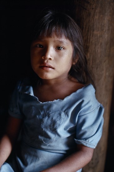 COLOMBIA, North West Amazon, Tukano Indigenous People, Portrait of young Makuna girl at the entrance to the maloca communal home. Tukano  Makuna Indian North Western Amazonia American Colombian Columbia Hispanic Indegent Kids Latin America Latino South America Tukano
