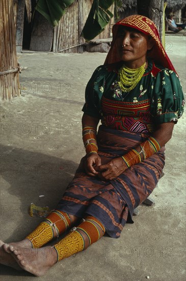 PANAMA, San Blas Islands, Kuna Indians, Kuna Indian woman wearing brightly coloured traditional layered applique mola  multi strand bead necklace  bead arm and leg bands and gold nose ring. Cuna Caribbean American Central America Classic Classical Colored Female Women Girl Lady Hispanic Historical Latin America Latino Older Panamanian West Indies