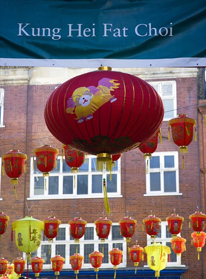 ENGLAND, London, Chinatown, Lion Dance troupe and musicians performing in Wardour Street amongst the crowd outside restaurants during Chinese New Year celebrations in 2006 for the coming Year of The Dog