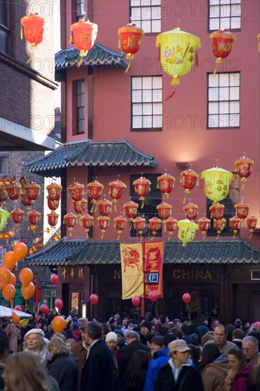 ENGLAND, London, Chinatown, Lion Dance troupe and musicians performing in Wardour Street amongst the crowd outside restaurants during Chinese New Year celebrations in 2006 for the coming Year of The Dog