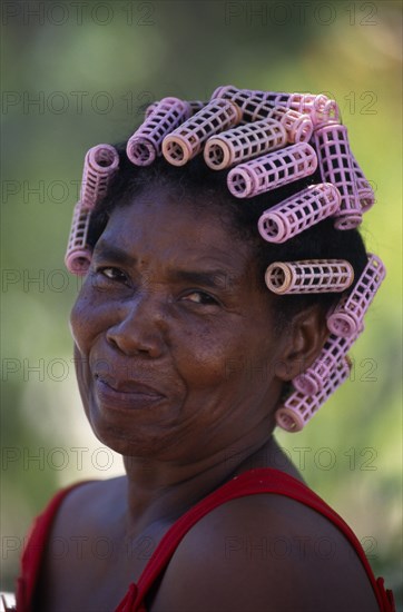 DOMINICAN REPUBLIC, Rodriguez, Head and shoulders portrait of Creole woman with her hair in pink plastic curlers.