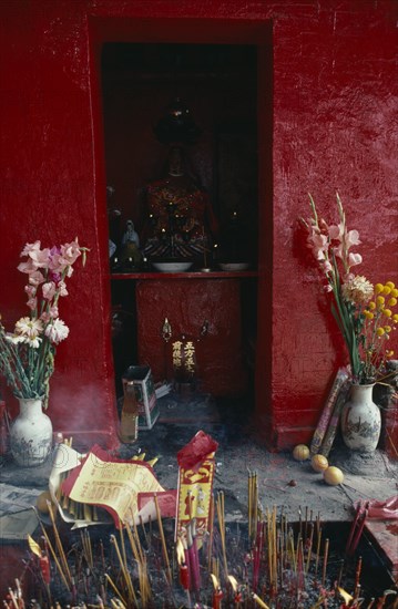 HONG KONG, Religion, Taoism, "Shrine dedicated to Tin Hau, the Taoist goddess of the sea beside Aberdeen Harbour.  Statue on red altar in red painted wall niche with offerings of flowers and incense."