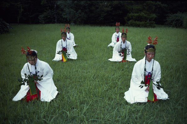 JAPAN, Honshu, Ise, Shrine maidens dance the ancient yamato mai near the Grand Shrine of Ise symbolizing the creation of Japan and the Japanese people.  They carry branches of the sacred sakaki tree.