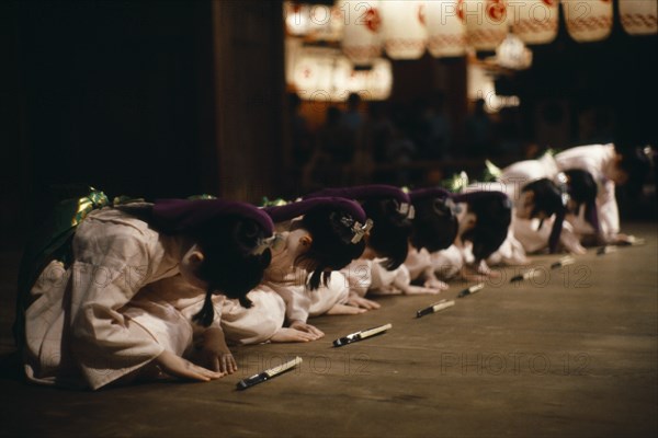 JAPAN, Honshu, Kyoto, During the Gion festival line of young girls finish their dance with a deep bow of respect to their audience and to the gods of the shrine.