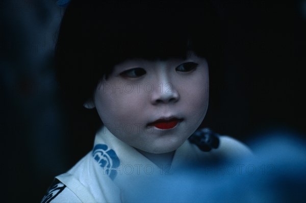 JAPAN, Honshu, Kyoto, Gion Festival. Portrait of young girl with white painted face signifying purity and gentleness of birth.
