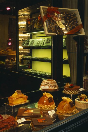 SWITZERLAND, Ticino, Lugano, Cakes and chocolate displayed in window of cafe.