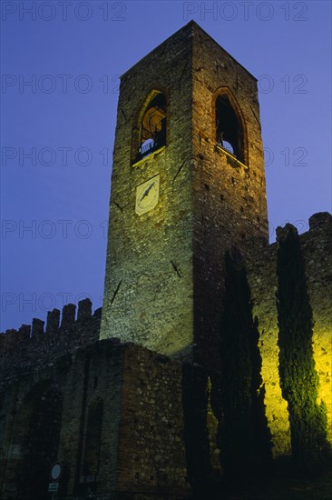 ITALY, Lombardy, Lake Garda , Manerba di Garda.  Castello crenellated walls and bell / clock tower illuminated at night.
