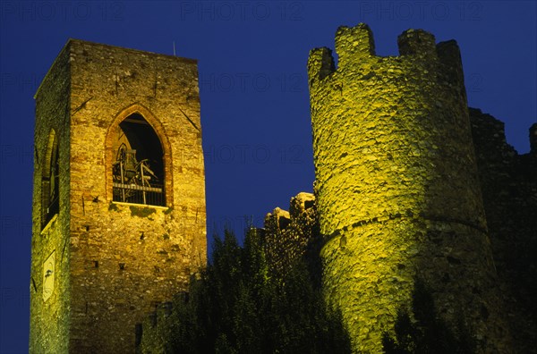ITALY, Lombardy, Lake Garda , Manerba di Garda.  Castello crenellated walls and bell / clock tower illuminated at night.