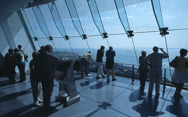 ENGLAND, Hampshire, Portsmouth, "Gunwharf Quays.The Spinnaker Tower. Interior with visitors looking out of glass windows on the top observation deck, providing a 320° view of the city of Portsmouth, the Langstone and Portsmouth harbours, and a viewing distance of 37 kilometres (23 miles)"