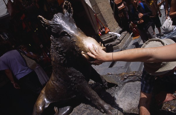 ITALY, Tuscany, Florence, Mercato Nuovo. Fontana del Porcellino. Bronze fountain of a boar with a woman rubbing the snout for good luck