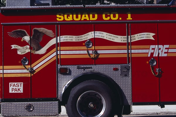 USA, New York, New York City, Part view of fire engine painted with Bald Eagle carrying banner listing some of the New York fire officers killed in the September 11th 2001 World Trade Tower attack.