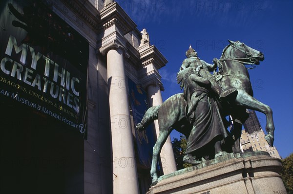 USA, New York, New York City, "American Museum of Natural History, Central Park West entrance with bronze statue of President Theodore Roosevelt on horseback and exhibition posters."