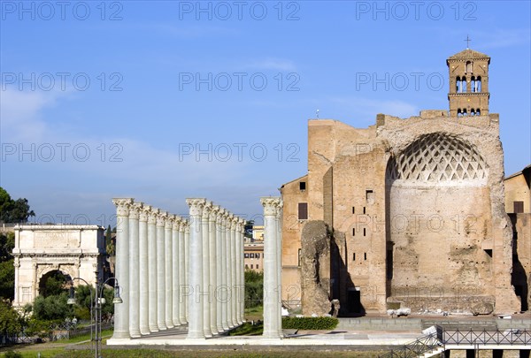 ITALY, Lazio, Rome, "The Forum The Temple of Venus and Roma (Latin: Templum Veneris et Romae) with fibregalss reconstructions of its Corinthian columns in the foreground. It was the largest known temple in Ancient Rome. Located at the far east side of the Forum Romanum near the Colosseum, it was dedicated to the goddesses Venus Felix (Venus the Bringer of Good Fortune) and Roma Aeterna (Eternal Rome). The architect was the emperor Hadrian. Construction of the temple began in 121. It was officially inaugurated by Hadrian in 135, and finished in 141 under Antoninus Pius. Damaged by fire in 307, it was restored with alterations by the emperor Maxentius. On the left is the Arch of Titus"