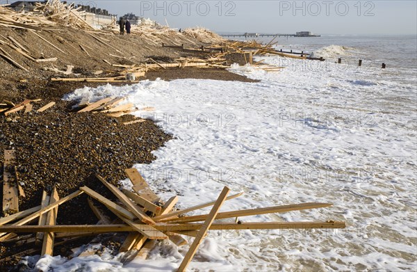 ENGLAND, West Sussex, Worthing, Timber washed up on the beach from the Greek registered Ice Princess which sank off the Dorset coast on 15th January 2008. People walking past waves crashing against the shoreline