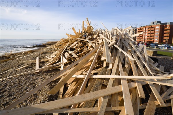 ENGLAND, West Sussex, Worthing, Timber washed up on the beach from the Greek registered Ice Princess which sank off the Dorset coast on 15th January 2008. People walk on the promenade with seafront buildings beyond