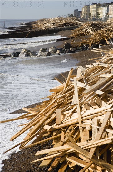 ENGLAND, West Sussex, Worthing, Timber washed up on the beach from the Greek registered Ice Princess which sank off the Dorset coast on 15th January 2008. Waves crash against the groynes with seafront houses beyond