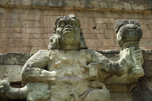 HONDURAS, Copan, Site of ancient Mayan ruins.  Detail of statue of figure holding burning torch.