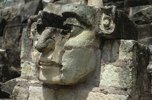 HONDURAS, Copan, "Site of ancient Mayan ruins.  Detail of carved stone face, partly complete, protruding from wall."