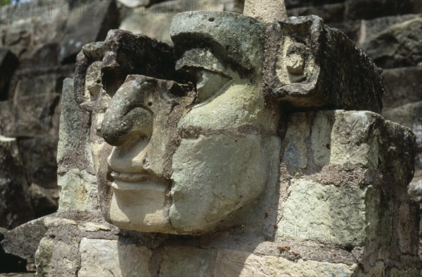 HONDURAS, Copan, "Site of ancient Mayan ruins. Detail of carved stone face, partly complete, protruding from wall."