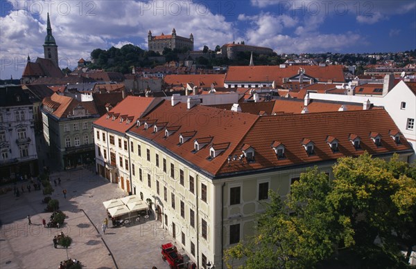 SLOVAKIA, Bratislava, View over paved square and red tiled rooftops of the Old Town towards Cathedral of St Martin and Bratislava Castle.