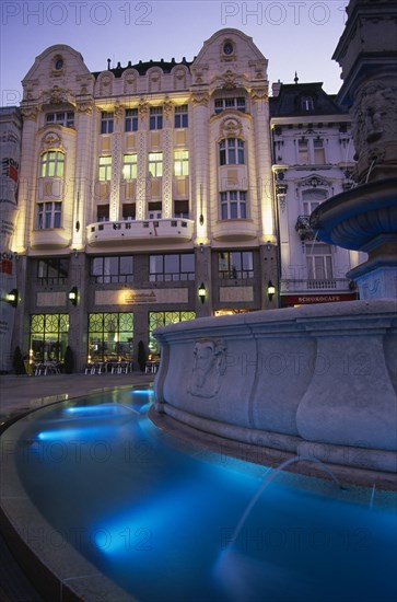 SLOVAKIA, Bratislava, Part view of Maximillian Fountain and the Cafe Rolanda on Hlavne nam (main square) at night.