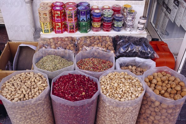 UAE, Dubai, Deira, Old souq in Eastern side of the town with sacks of nuts and flower petals displayed on stall.