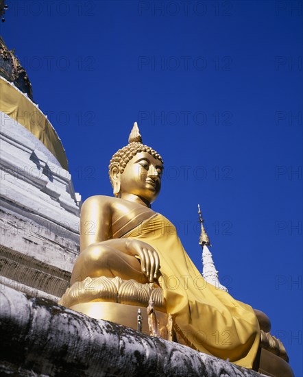 THAILAND, North, Chiang Mai, Seated golden Buddha statue robed in gold silk.