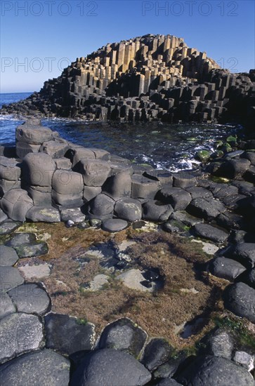 NORTHERN IRELAND, Co Antrim, Giants Causeway, Interlocking basalt stone columns left by volcanic eruptions. View across the main and most visited section of the causeway