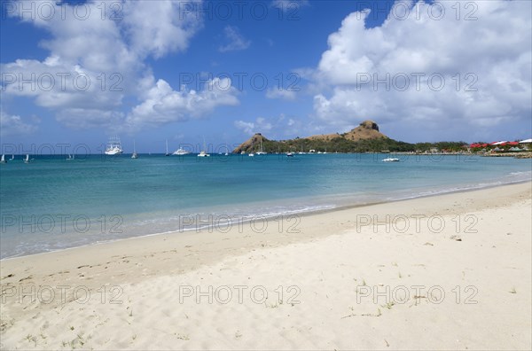 WEST INDIES, St Lucia, Gros Islet , Pigeon Island National Historic Park seen from a nearby beach on a causeway to the island with yachts at anchor in Rodney Bay