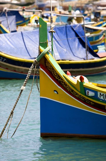 MALTA, Marsaxlokk , Fishing village harbour on the south coast with colourful Kajjiki fishing boats with the Eyes of Osiris on the bow