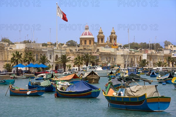 MALTA, Marsaxlokk , Fishing village harbour on the south coast with colourful Kajjiki fishing boats and the Church dedicated to Our Lady of the Rosary The Madonna of Pompeii